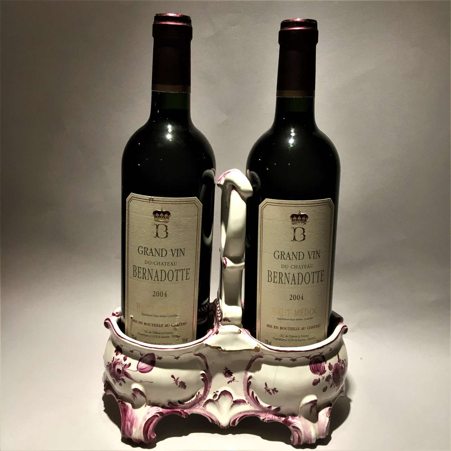 An unusual faïence, tin-glazed earthenware, double wine bottle coaste